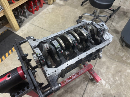 Engine block upside down on a stand with the crankshaft and main caps installed